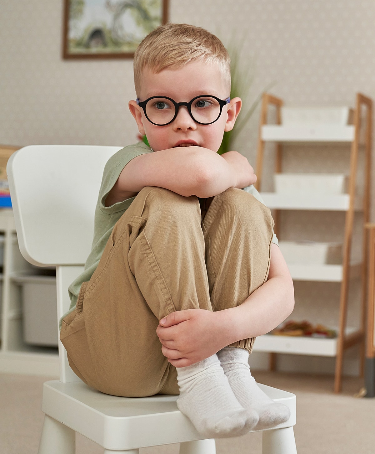 Torrance ASD treatment boy sitting on a chair, looking thoughtful.