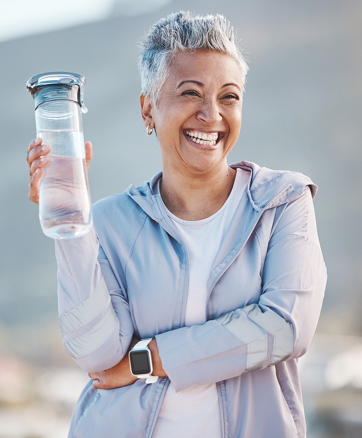 Smiling Torrance wellness assessment woman holding a water bottle outdoors.