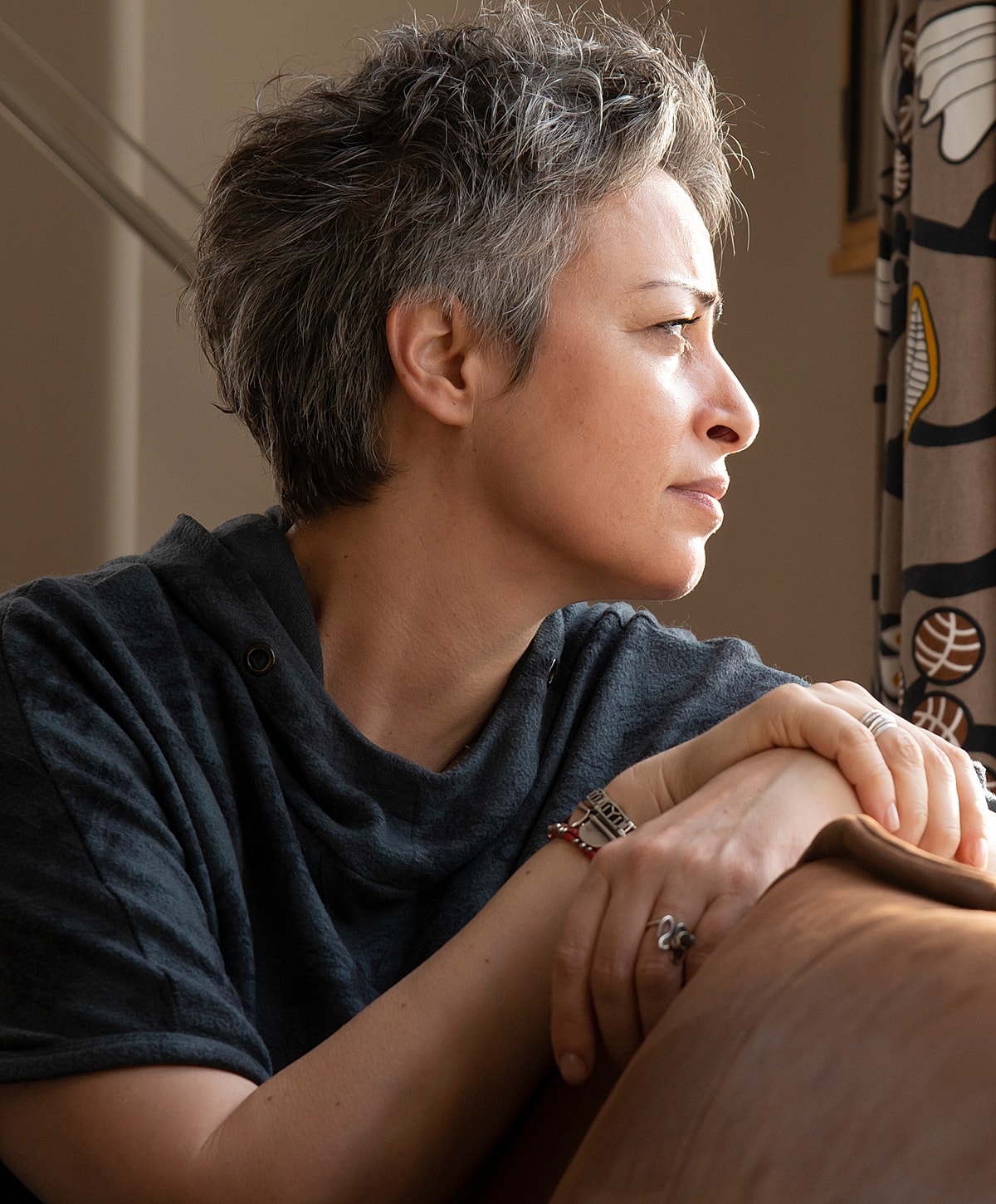 Thoughtful woman gazing out a window, in need of Torrance POTS treatment.
