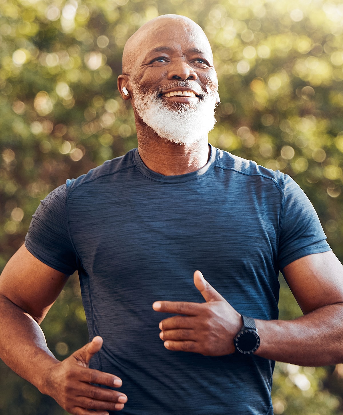 Smiling Torrance regenerative medicine man jogging outdoors in sports attire.