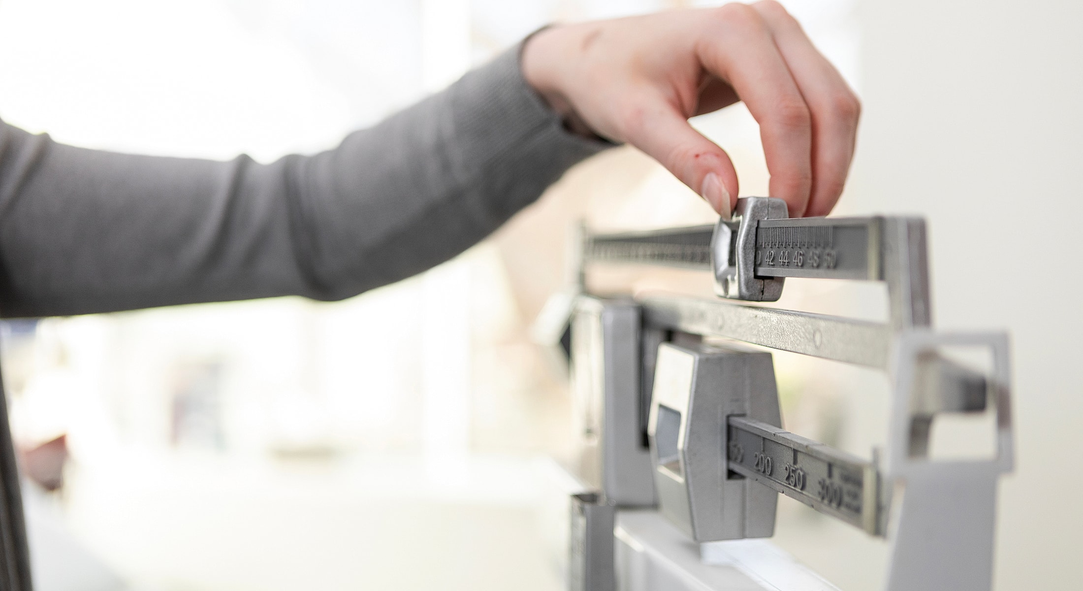 Torrance obesity treatment person adjusting weights on a balance scale.