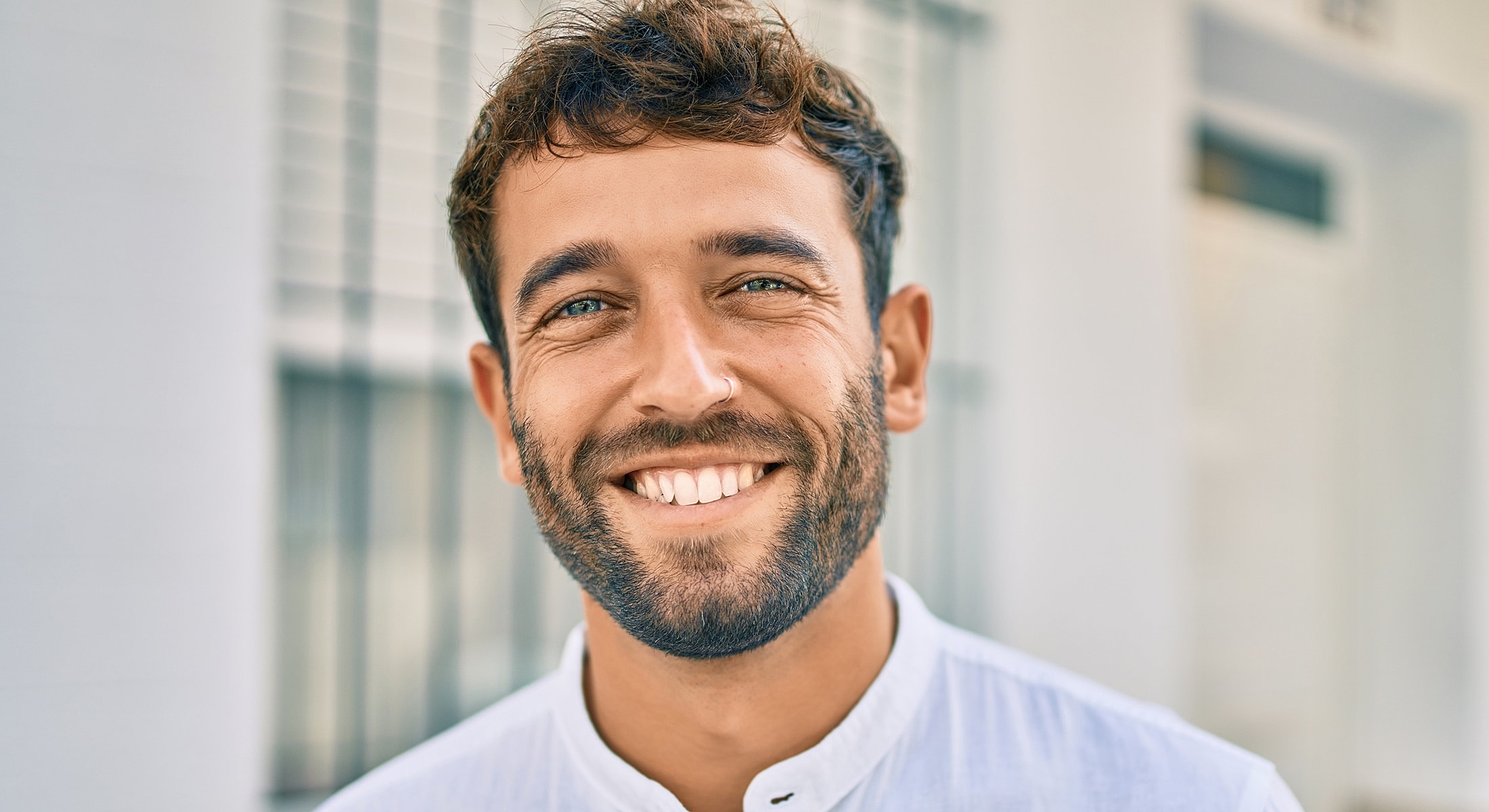 Smiling Torrance POTS treatment man with beard wearing a white shirt.