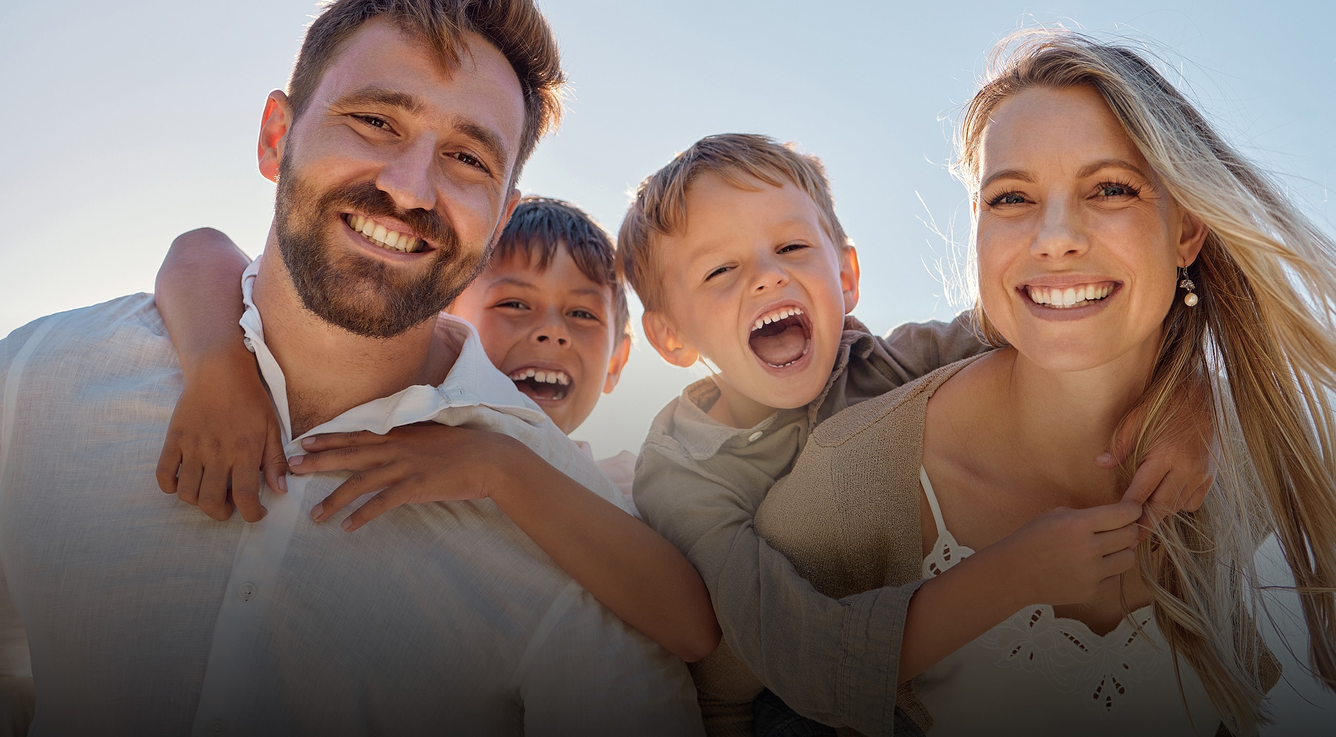 Family walking along the beach at sunset.